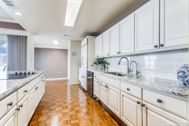 kitchen featuring white cabinets, black electric cooktop, and sink