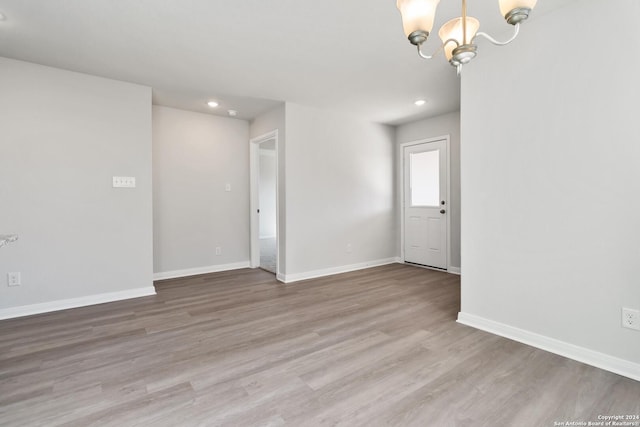 empty room featuring hardwood / wood-style floors and an inviting chandelier