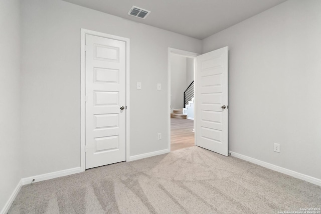 spare room featuring light colored carpet