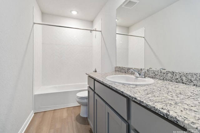 full bathroom with hardwood / wood-style floors, vanity, toilet, and shower / bathing tub combination