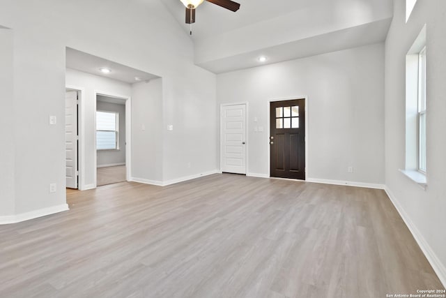 interior space with ceiling fan, light hardwood / wood-style flooring, high vaulted ceiling, and plenty of natural light