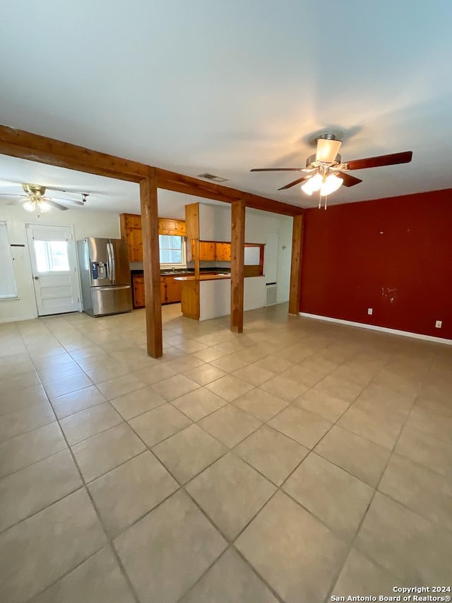 unfurnished living room featuring ceiling fan and light tile patterned floors