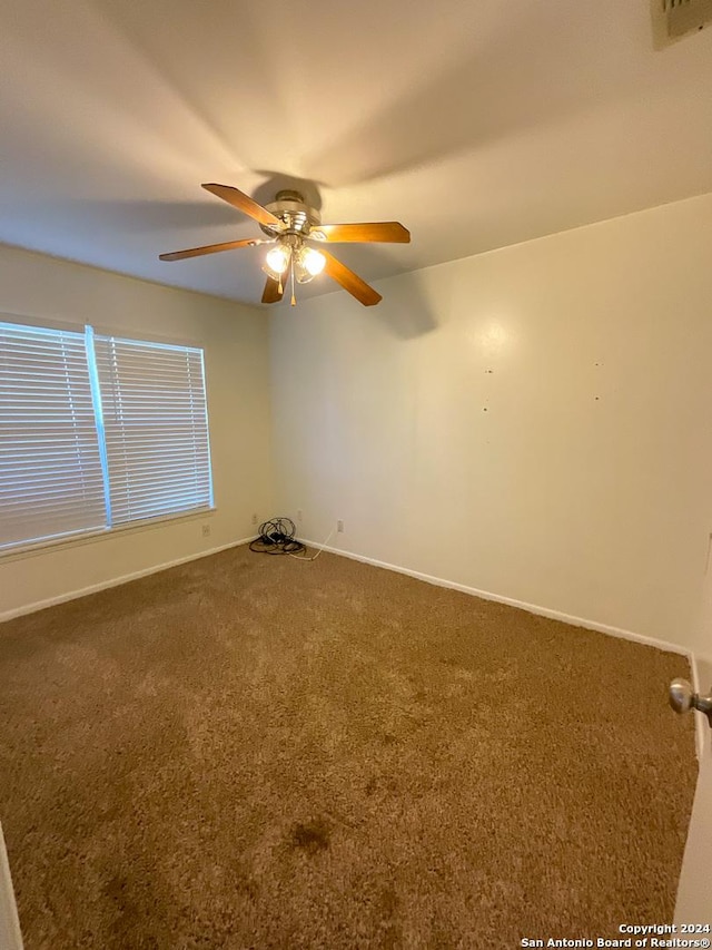 carpeted empty room featuring ceiling fan