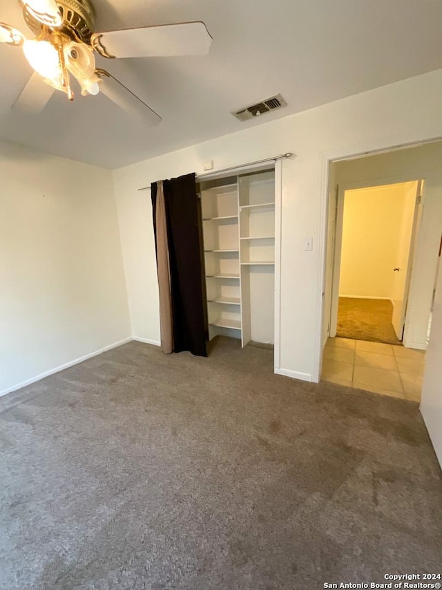 unfurnished bedroom with ceiling fan, carpet floors, and a closet