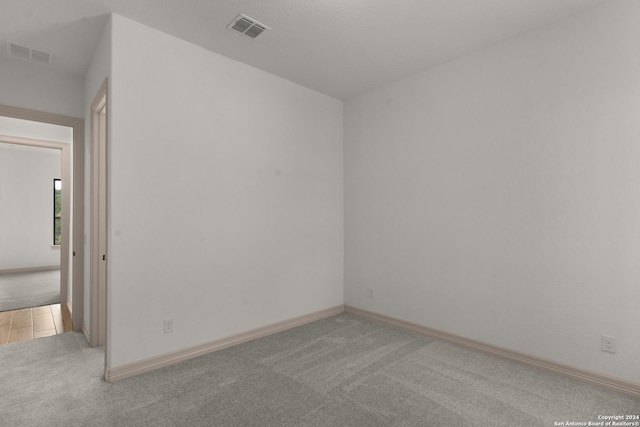 spare room featuring light colored carpet