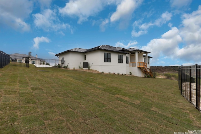 rear view of house featuring a yard and cooling unit