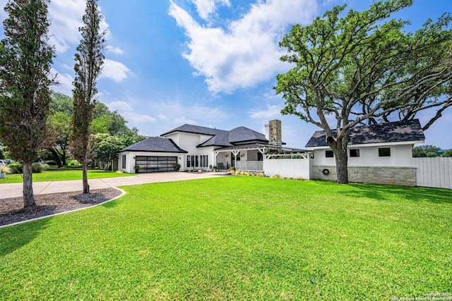 view of front of house with a garage, driveway, a front yard, and fence