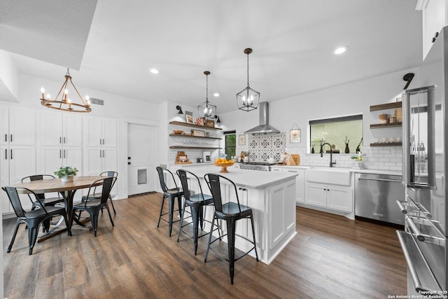 kitchen featuring refrigerator, a sink, stainless steel dishwasher, wall chimney range hood, and open shelves