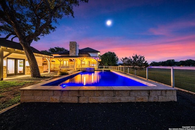 pool at dusk with a patio area