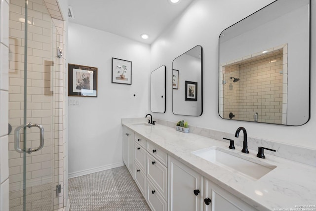 bathroom with double vanity, a stall shower, a sink, and visible vents