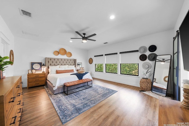 bedroom with recessed lighting, wood finished floors, a ceiling fan, baseboards, and visible vents