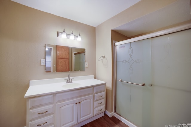 bathroom featuring hardwood / wood-style floors, vanity, and walk in shower