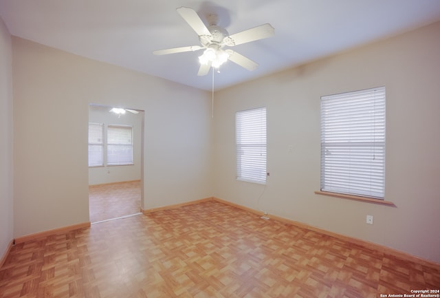 unfurnished room with ceiling fan and light parquet floors