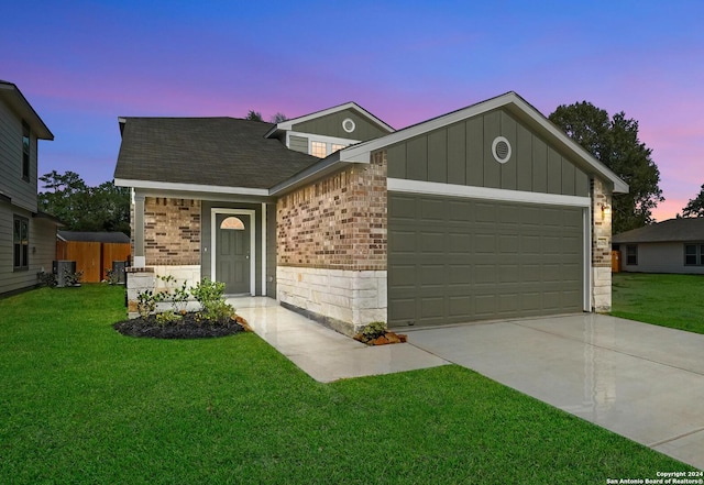 view of front of house with central AC, a yard, and a garage