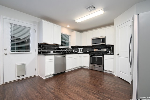 kitchen featuring white cabinets, appliances with stainless steel finishes, dark hardwood / wood-style flooring, and tasteful backsplash