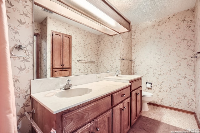 bathroom featuring vanity, toilet, and a textured ceiling