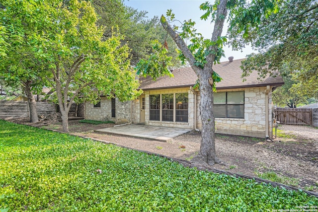 back of house featuring a patio area and a lawn