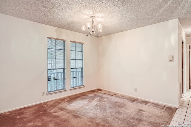 unfurnished room featuring carpet, a textured ceiling, and a chandelier