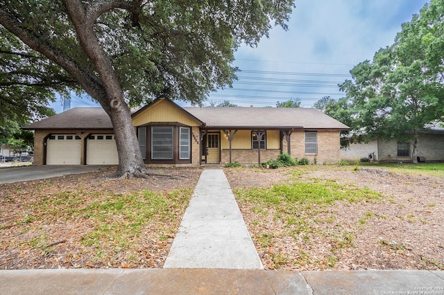 ranch-style house featuring covered porch and a garage