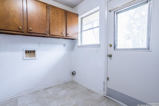 laundry area with hookup for a washing machine, cabinets, and a wealth of natural light