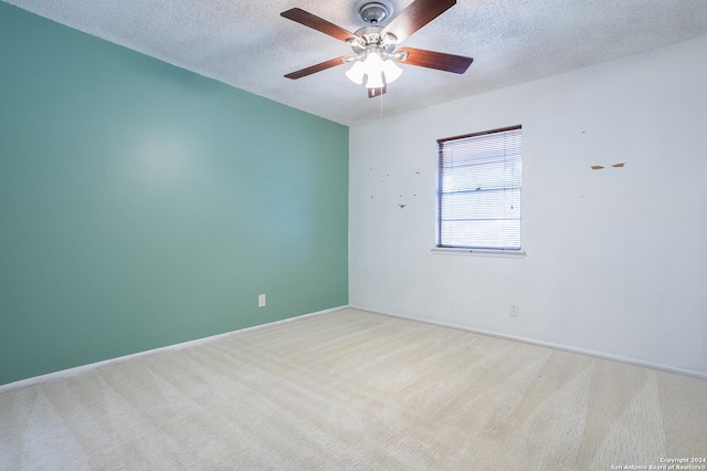 carpeted empty room featuring ceiling fan and a textured ceiling