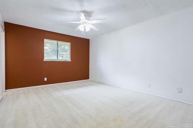 carpeted spare room featuring a textured ceiling and ceiling fan