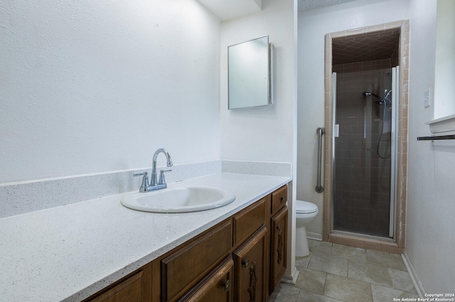 bathroom with vanity, toilet, and a shower with shower door