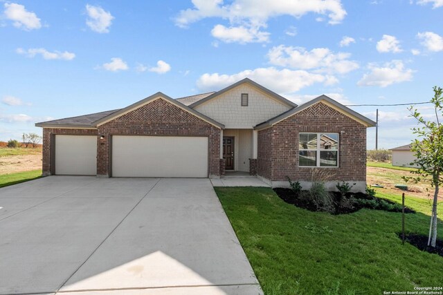 view of front facade featuring brick siding, concrete driveway, a front lawn, and a garage