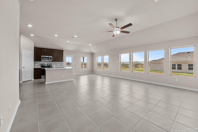 unfurnished living room with vaulted ceiling, light tile patterned floors, baseboards, and ceiling fan