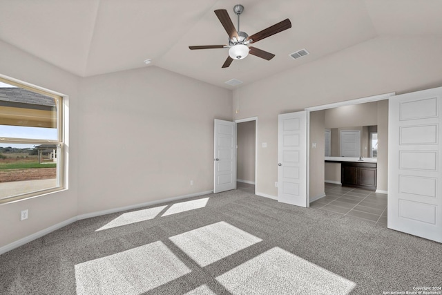 unfurnished bedroom featuring baseboards, visible vents, vaulted ceiling, ensuite bathroom, and light carpet