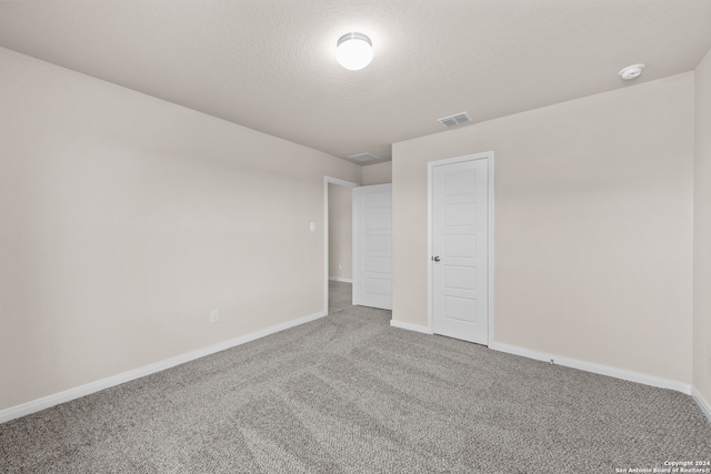 unfurnished bedroom with visible vents, baseboards, carpet, and a textured ceiling
