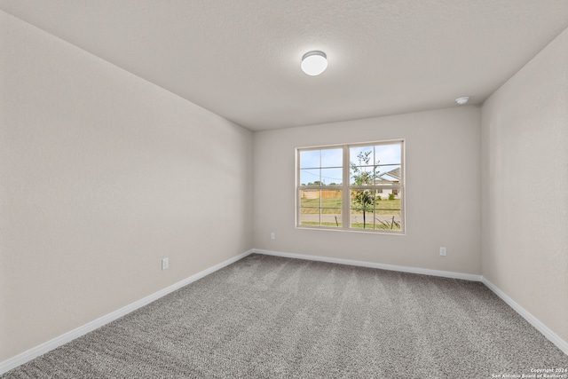 carpeted spare room featuring baseboards
