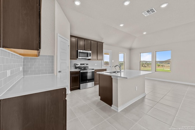 kitchen featuring visible vents, light tile patterned flooring, stainless steel appliances, light countertops, and vaulted ceiling