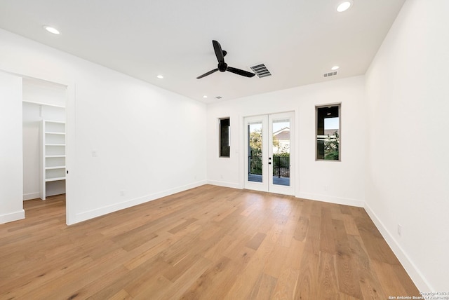 empty room with french doors, ceiling fan, and light hardwood / wood-style flooring