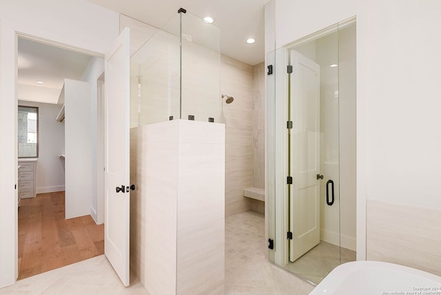 bathroom with hardwood / wood-style floors and plus walk in shower