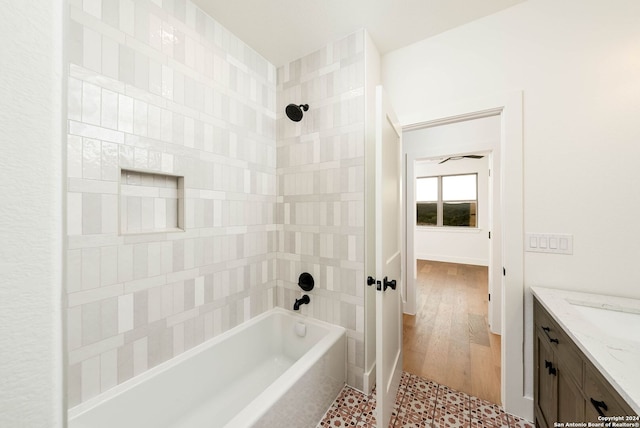 bathroom with vanity, hardwood / wood-style floors, and tiled shower / bath combo