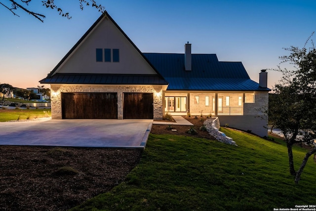 view of front facade featuring a garage and a lawn