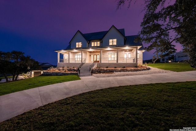 view of front of home featuring covered porch and a lawn