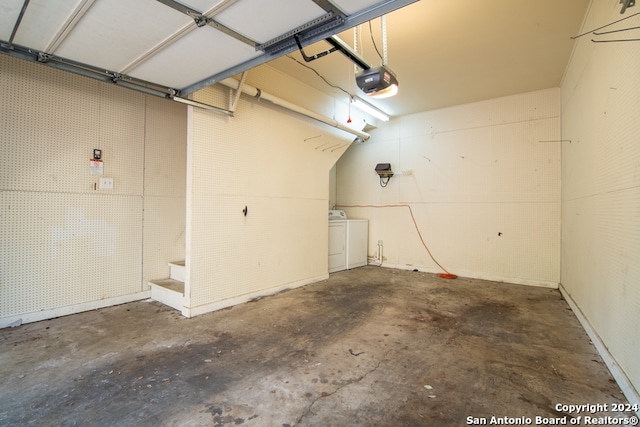 garage featuring independent washer and dryer and a garage door opener