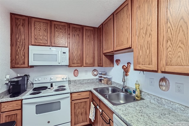 kitchen with a textured ceiling, white appliances, and sink