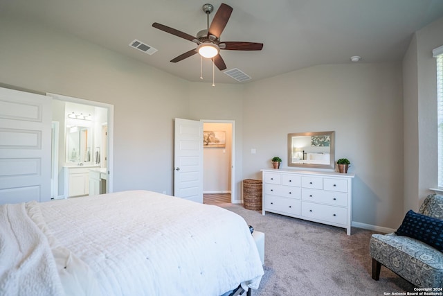 bedroom with ceiling fan, ensuite bathroom, light colored carpet, and vaulted ceiling