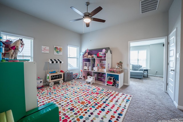 playroom featuring ceiling fan, light colored carpet, and a healthy amount of sunlight