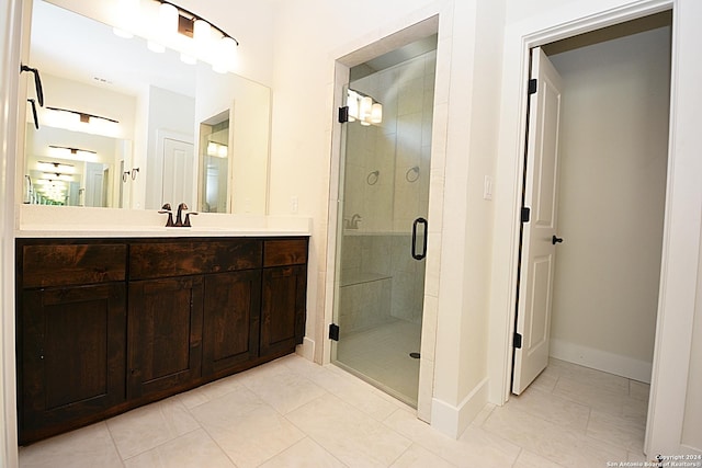 bathroom featuring tile patterned floors, vanity, and a shower with door