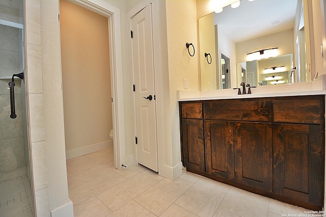 bathroom featuring tile patterned flooring, vanity, walk in shower, and toilet