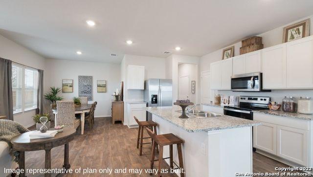 kitchen featuring white cabinets, appliances with stainless steel finishes, an island with sink, sink, and dark hardwood / wood-style floors