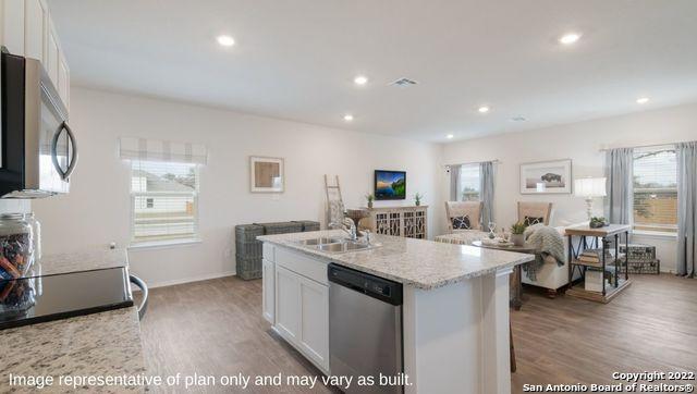 kitchen featuring stainless steel appliances, an island with sink, white cabinets, and sink