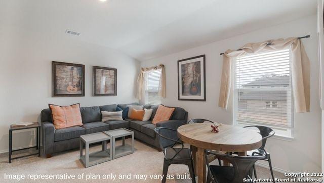 carpeted living room featuring vaulted ceiling