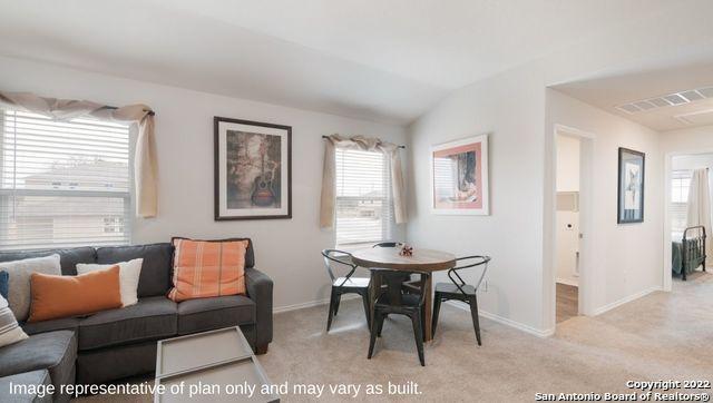 dining area with lofted ceiling and light colored carpet