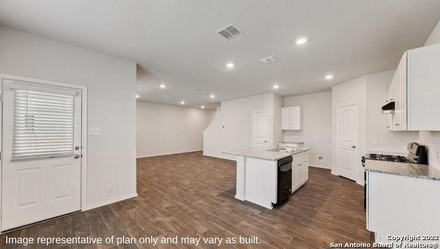 kitchen featuring an island with sink, dishwasher, white cabinets, and dark hardwood / wood-style flooring