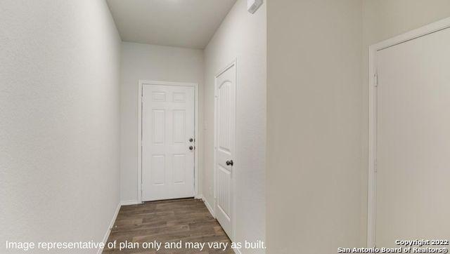 hallway with baseboards and wood finished floors